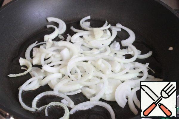 Onions cut into half rings. In a preheated frying pan, I pour vegetable oil, throw the onion. Fry for 1-2 minutes, until golden brown.