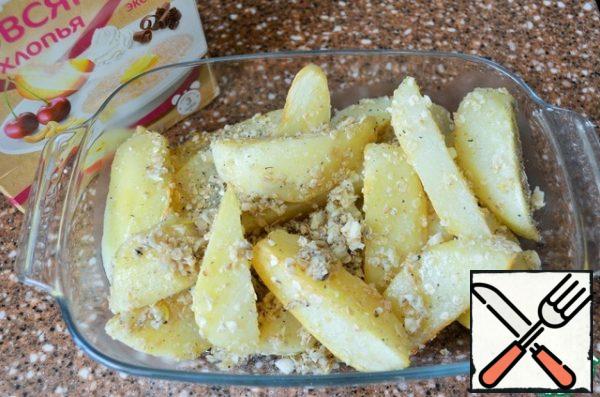 Put the potatoes in a heat-resistant form,
season with flakes and garlic.