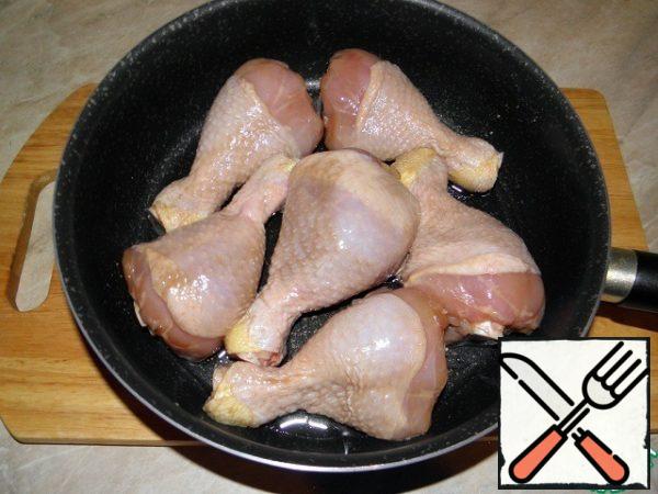 Place the chicken pieces in a greased frying pan.