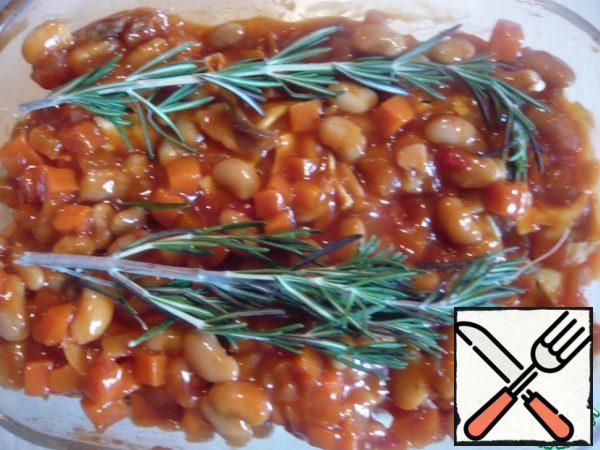 We put our nuts in a greased form. Add the canned beans on top. And a sprig of rosemary.