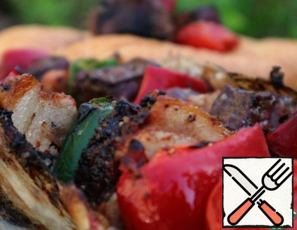 Spread out the steel mesh, sprinkle with salt, pepper, paprika and spices as desired. Shish Kebab from the liver is wrapped in a net and placed on the grill until fully cooked.