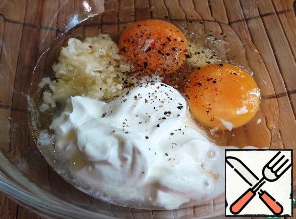 Preparing the batter.
Peel the garlic and squeeze it through the garlic press.
Mix the egg, garlic, sour cream or mayonnaise, salt, pepper.