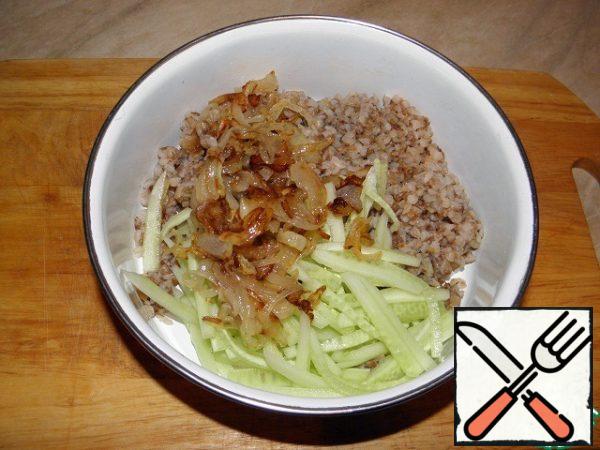 To the buckwheat porridge, add the fried onion, cucumber, mix, add salt and pepper to taste.