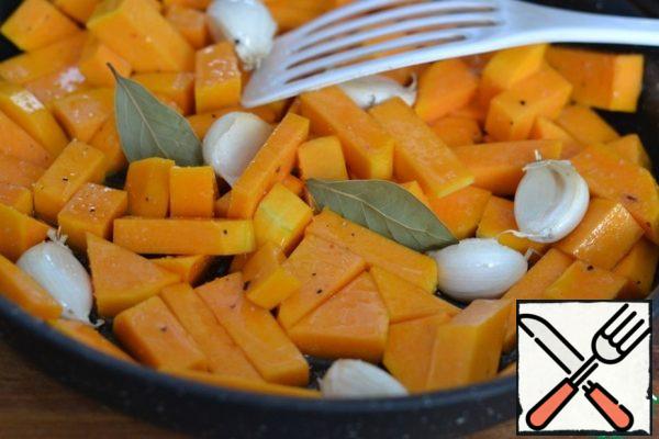 Put the pumpkin and garlic in a baking dish. Add 2 tablespoons of sunflower oil, salt and pepper. Add the bay leaf. Mix well. Bake in a preheated oven at 200g for 20 minutes.