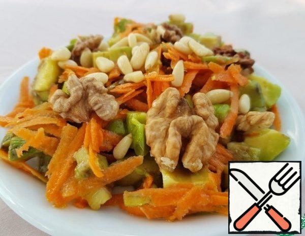 Grate the carrots on a coarse grater. Fry the crushed nuts in a pan and set aside. Cut the avocado pulp into identical pieces and put them in a bowl with orange juice. 