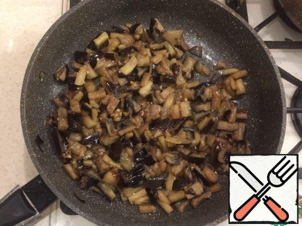 Finely chop the eggplants, cover with salt and leave for 20 minutes until moisture is released. Rinse well. Simmer in a frying pan until fully cooked. During cooking, add the garlic and a little salt (some salt has already been absorbed by the eggplant at the initial stage).