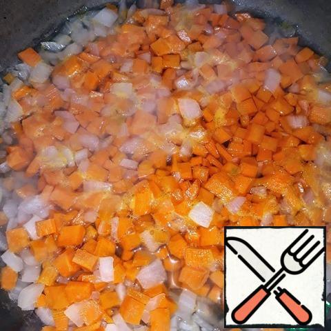 Cut the carrots and onions into cubes, pour the water into the pan and pour the slicing into it. Simmer the vegetables under the lid for about 7 minutes.