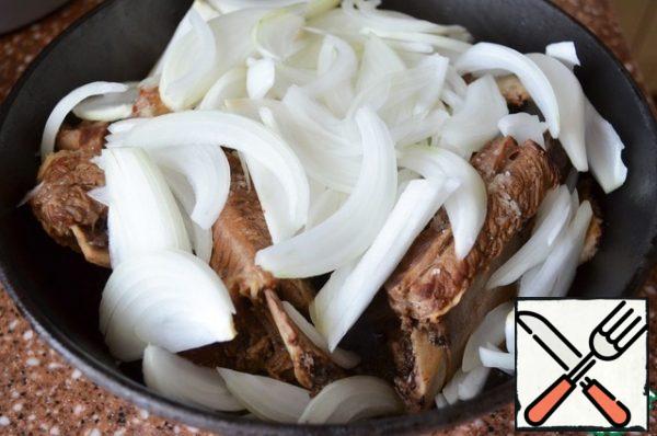 Cut the onion into feathers and put it on the meat.
Simmer under the lid over medium heat for 20 minutes.
