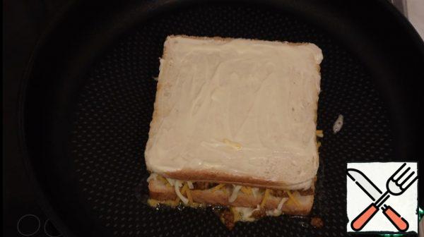 Put the toast in a preheated frying pan with mayonnaise on the bottom, lubricate the second part with mayonnaise, fry until crisp