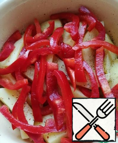 Then the Bulgarian pepper is placed on the potatoes, cut into strips.