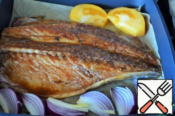 Preheat the pan, brush the fish with vegetable oil. Put the fish on parchment, skin down, add salt and fry for 3 minutes, the heat is above average. Also fry the onion and tomato slices.