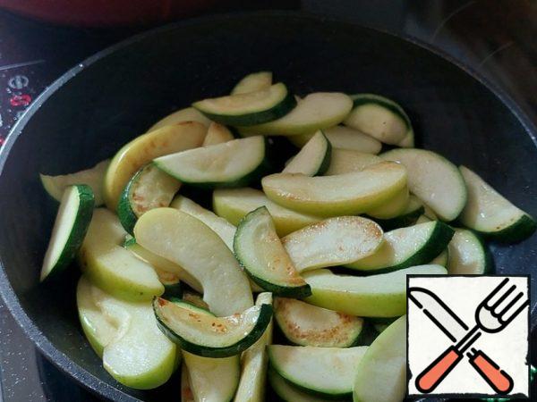 Grease the pan with vegetable oil. In a hot frying pan, fry the apple over medium heat for 5-7 minutes until soft. Add the zucchini and fry them together with the apples on high heat for 3-4 minutes.