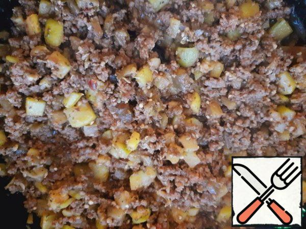 Add the vegetables and tomato paste to the minced meat. Fry everything together over medium heat, stirring constantly for 15 minutes until the vegetables are cooked.