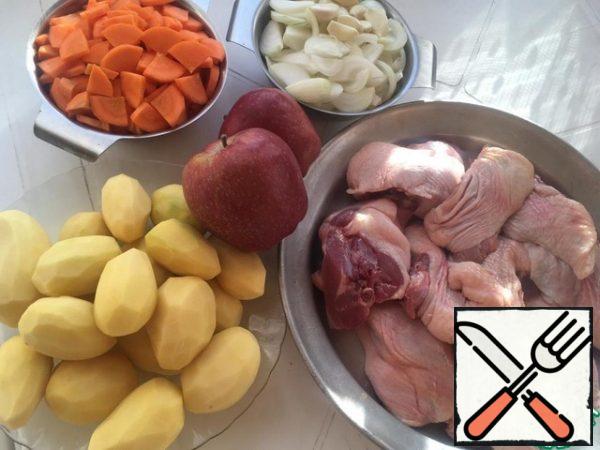 Prepare all the ingredients. I have already cut up the duck, onion feathers, carrots in half circles, garlic whole cloves, apples in quarters, removing the seeds.