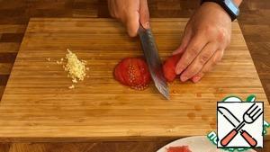 Chop the garlic and tomato.