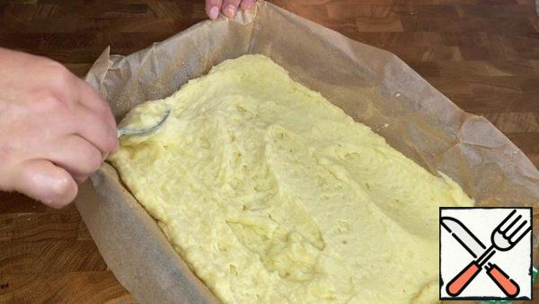 Cover the form with baking paper, grease with vegetable oil and sprinkle with breadcrumbs. Divide the dough into two unequal parts. Put most of it on the bottom of the mold.