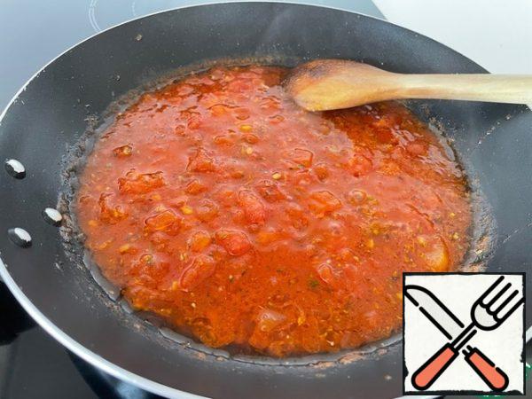 We prepare the sauce. Peel the tomatoes from the skin and cut into small cubes, lightly stew in oil, add tomato paste, spices and salt for an intense color. Depending on whether you like a lot of gravy in the dish, add water. It usually takes me 100 ml. Cook everything together for 5 minutes