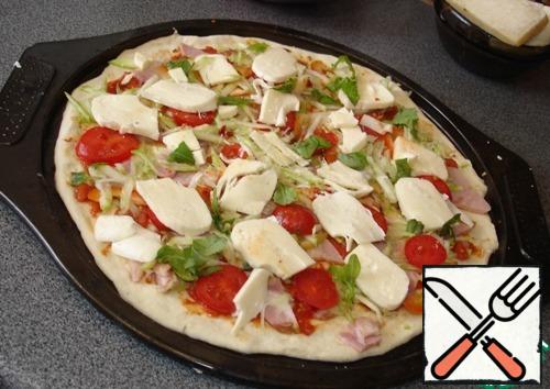 Spread all the prepared vegetables evenly on the pizza. Cut the mozzarella into slices, cover with the vegetable filling.