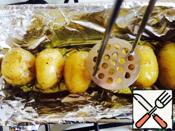 After 30 minutes, remove the potatoes. An interesting point: take a mashed potato masher and lightly press on each potato so that it is slightly kneaded. Then pour the fragrant mixture and send it back to the oven for 20-25 minutes.