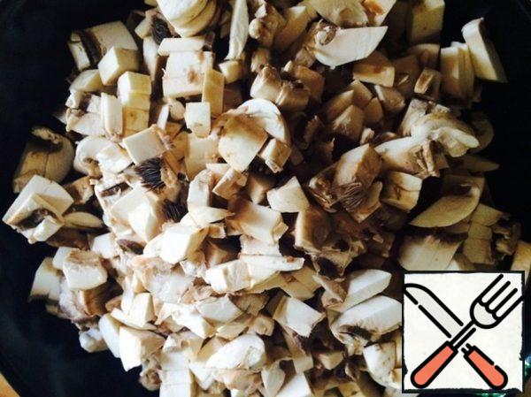 In the meantime, let's do the mushrooms. We cut them finely.