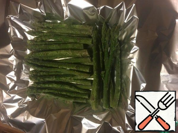 Spread the foil and put the asparagus on it, in general, asparagus can be replaced with any frozen vegetables (beans, broccoli, etc.)