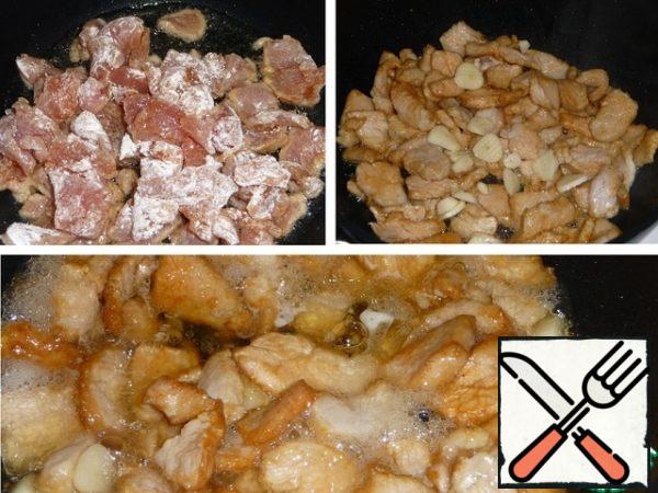 In a cauldron or deep frying pan, heat the vegetable oil, lower the meat into boiling oil, lightly fry, add garlic, fry briefly, pour in white wine. Evaporate completely.