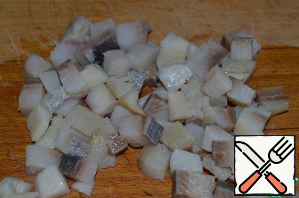Cut the herring fillet into cubes.