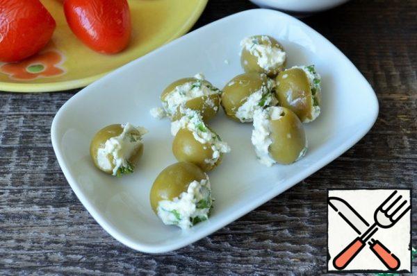 Stuff the olives with cottage cheese mass.
