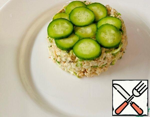 Cook the rice, mash the pink salmon, rub the cucumber, add mayonnaise in one container and mix. 