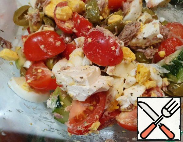 6.Put cucumbers, tomatoes, olives, eggs, cheese and tuna on top in a salad bowl.
7. Sprinkle with spices.
8. Season the salad with olive oil.
9. Mix.
