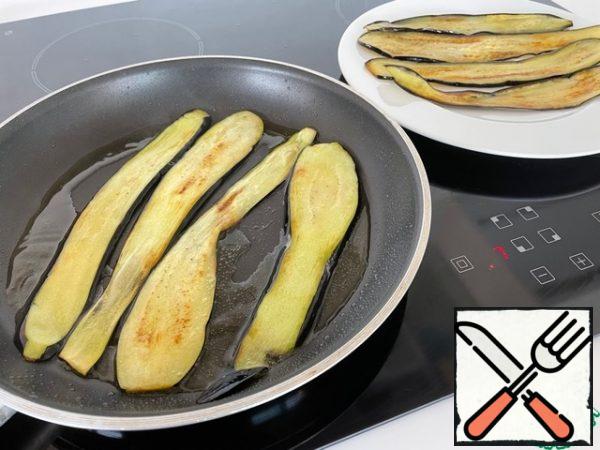 Heat the oil in a frying pan and fry the eggplants on both sides.