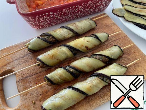 We wrap our minced meat preparations on skewers in eggplants. If the eggplant plates are wide, you can cut them into two strips.