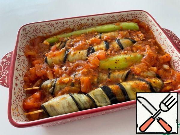 We put wrapped kebabs and overcooked peppers in a baking dish. Pour the tomato sauce over it.
