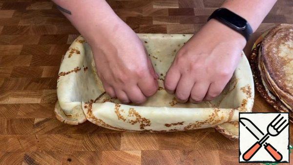 I will not tell you how to make pancakes, there are many good recipes on the site with a step-by-step description. I baked pancakes in a frying pan with a diameter of 28 cm. And my cake mold is 23/14 and 6 cm deep. We line the form with pancakes leaving free edges.