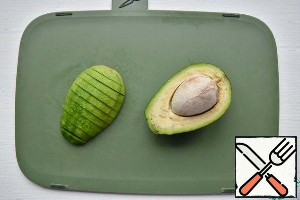 Remove the avocado from the skin and bones, cut into slices and also marinate in lime juice with salt and pepper.