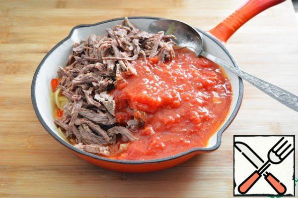 When the peppers and onions are slightly fried, add the beef disassembled into fibers and mashed tomatoes in their own juice to the pan and pour in the broth. Simmer all together for about 2-3 minutes