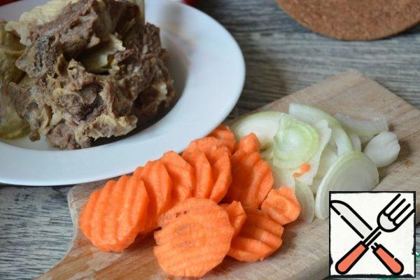 Get the meat, strain the broth. Pour the broth into a clean cauldron, add half the onion and carrot pieces. Cook for 10 minutes.