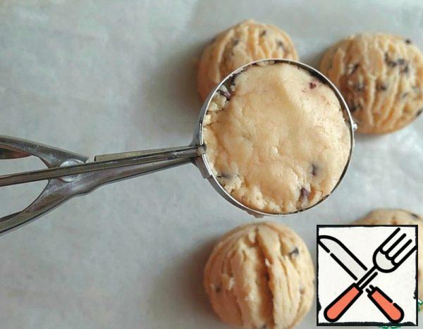 Fill the ice cream spoon with dough, lightly tamp it down.