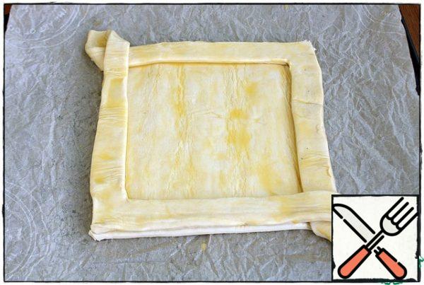 We do the same with the other side and transfer it to the vacant part of the square. We trim the sides, press them slightly so that they are glued to the square and also lubricate the egg on top, send it to the preheated oven for 10-15 minutes.