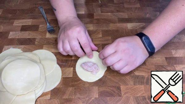 Put one teaspoon of the filling on a circle. Fold in half and blind the edges well.