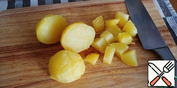 Boil 2-3 potatoes (the author has 1), in the peel until ready, cool, clean, cut coarsely.