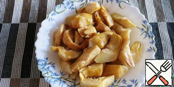 We decant artichokes from the oil. In the original, they are fresh, but now, alas, it is not the season.