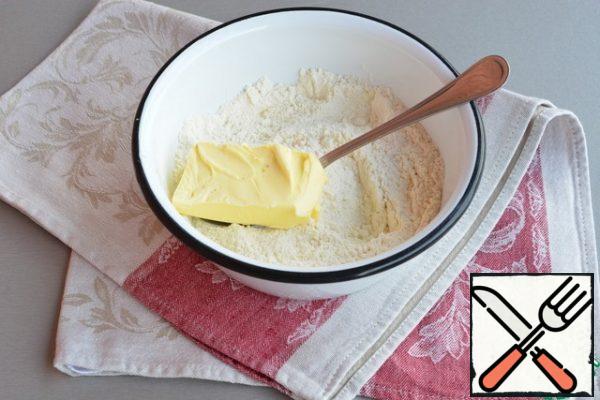 Add baking powder, salt to the flour, mix. Add the butter and chop it with a knife in flour, and then rub it with your hands to get a fine crumb, add sugar.