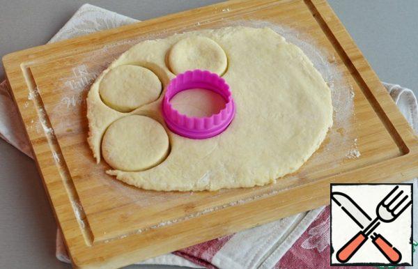 Roll out the dough into a layer 1-2 cm thick, cut out round scones with a mold 5-7 cm in diameter. Brush the tops with the remaining egg and milk mixture.