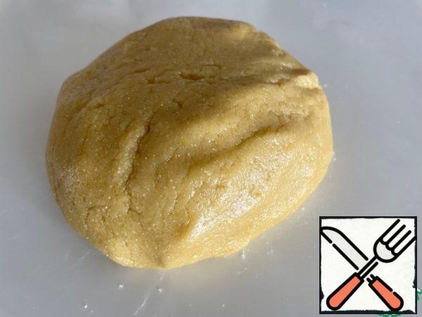 We add the remaining components. We use half a glass of semolina in the dough. You can add a pinch of salt, vanilla and lemon zest. Flour took 2.5 cups and 1 tablespoon with a slide. We knead a rather fat dough, similar to soft plasticine.