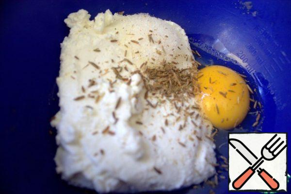 For the filling, beat an egg into the cottage cheese, add cumin, sugar. I ground the cumin in a mortar for flavor.