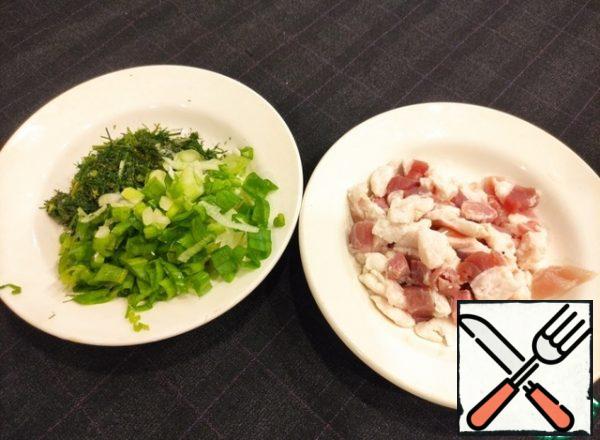 Cut the fat into cubes not finely, about 1 cm, cut the greens, onion in half rings.