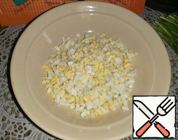 Boil the eggs, cool and cut into small cubes.