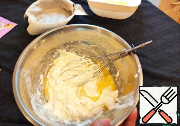 Stir the yolks with a whisk by hand and add baking powder, sugar, starch and sour cream, knead until smooth.