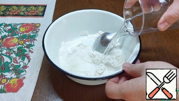 While the vegetables are fried, pour 80 g of flour into a bowl. In small portions, stirring each time, add 100 ml of water. The result should be a homogeneous mass without lumps.